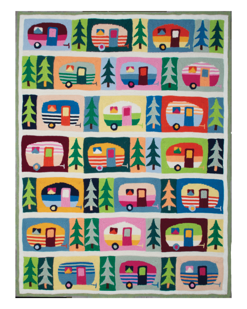 A knitted blanket featuring colorful camper vans and trees. The Camp Along Blanket, is a design by Margaret Holzmann.