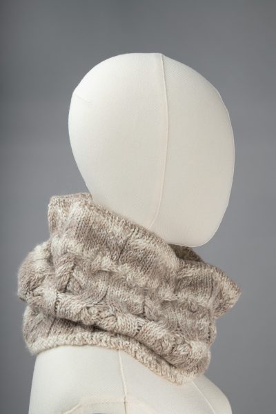 Light-colored white and tan cowl on a white mannequin. The Twisted Rope Cowl designed by Jennifer Kent is a Cascade Yarns free pattern.